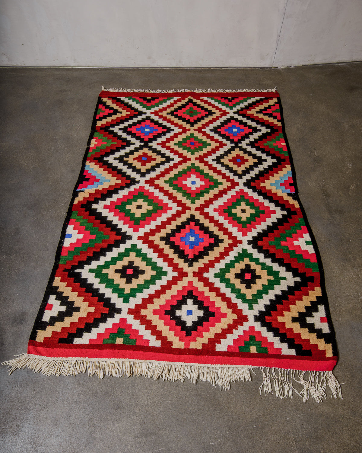 Colorful geometric patterned rug on a plain floor